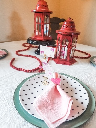 Make easy decorations for a table, plates made with cardboard, dressed up napkin rings and a centerpiece with vintage images and bead garland.