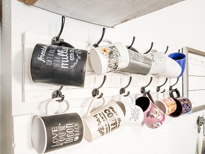 White Shutter with black hooks and hanging coffee cups