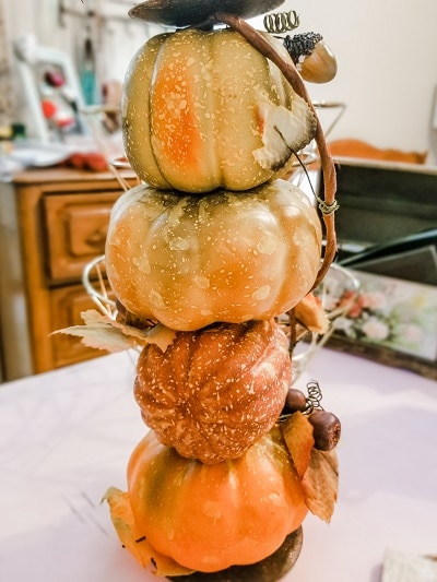 A pumpkin candlestick repurposed for fall mantel