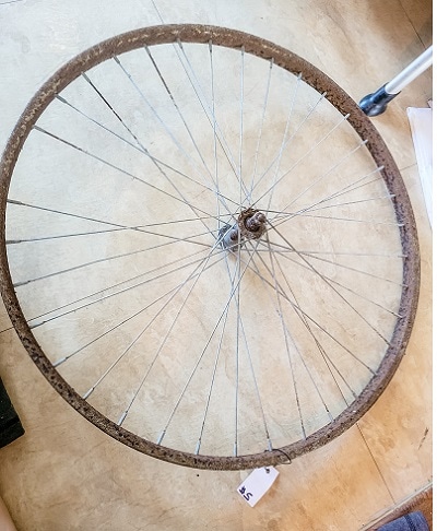 A bike wheel rim gets new life as a spider web on a Halloween Mantel