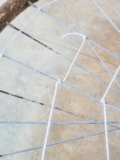 A bike wheel rim gets new life as a spider web on a Halloween Mantel