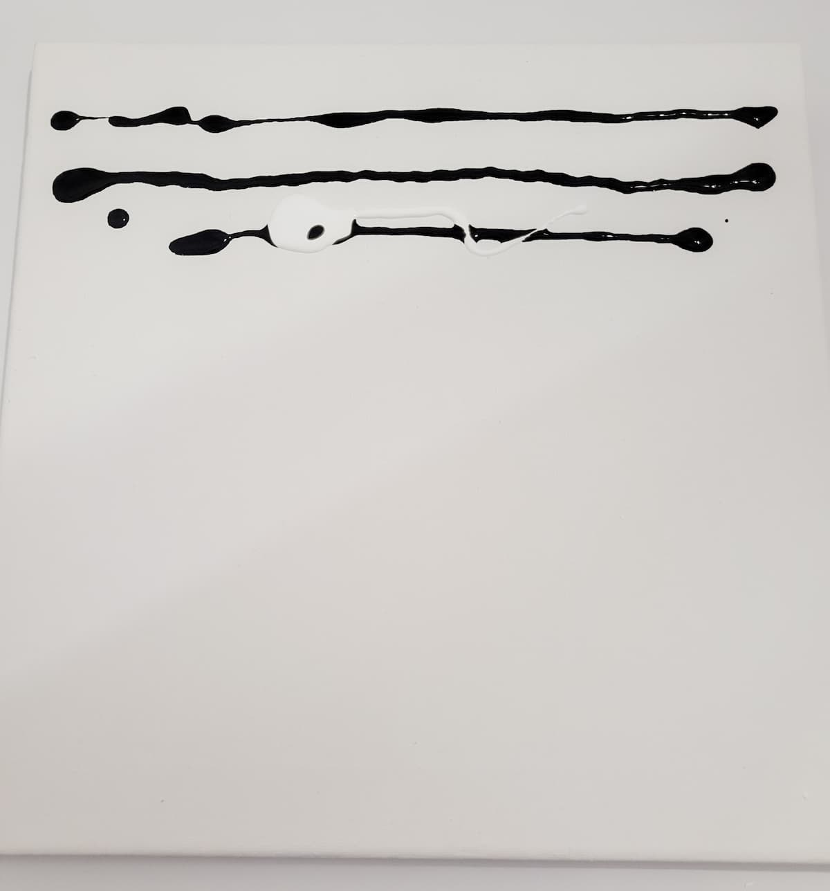 three lines of black paint on white canvas