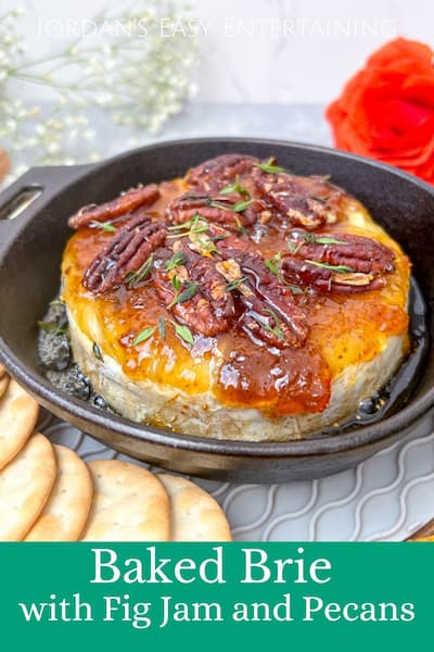 piece of brie cheese in black pan with pecans and figs on top