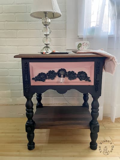black nightstand with pink drawer and black embellishments