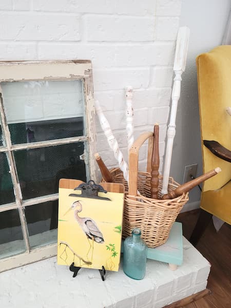 Wicker basket of spindles a clipboard with bird picture, glass bottle.