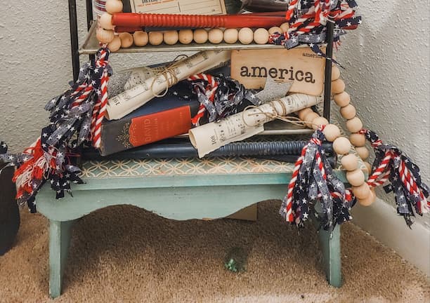 Fourth of July Tiered tray with vintage flash cards, ephemera, antique pieces and a wood bead garland for each season with fabrics tassels.