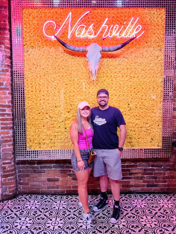 Couple in front of orange wall in Nashville