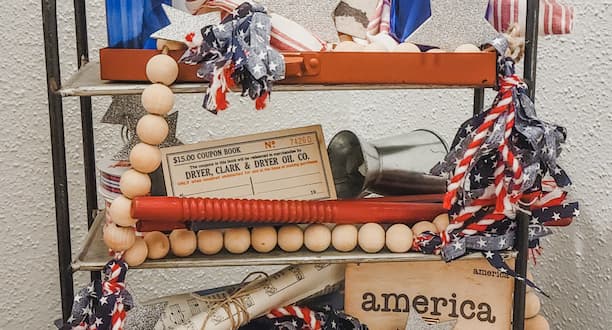 Fourth of July Tiered tray with vintage flash cards, ephemera, antique pieces and a wood bead garland for each season with fabrics tassels.