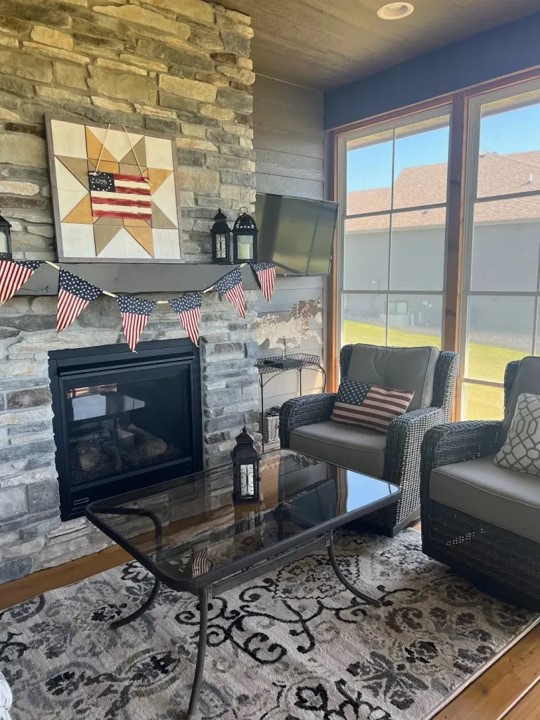 fireplace with barn quilt and two chairs