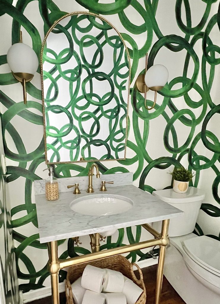 bathroom with green/white wallpaper, stand sink