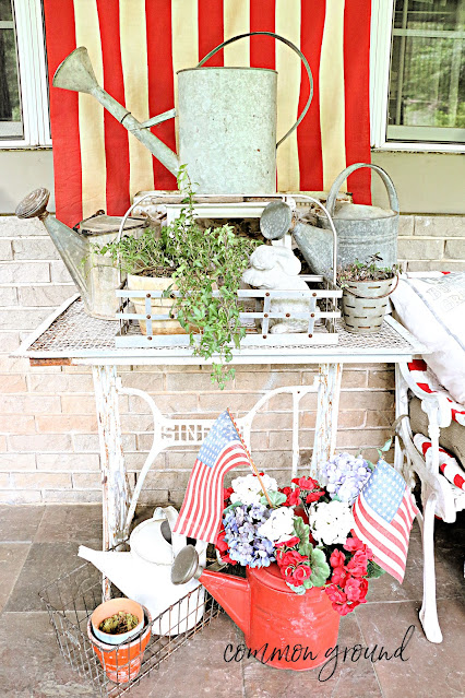 Sewing machine table with watering cans and patriotic decor
