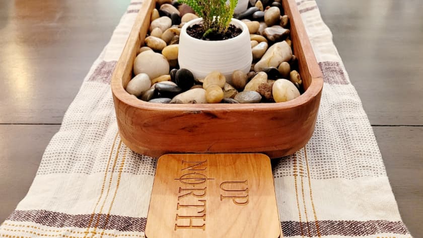 succulents and rocks in wood bowl on table