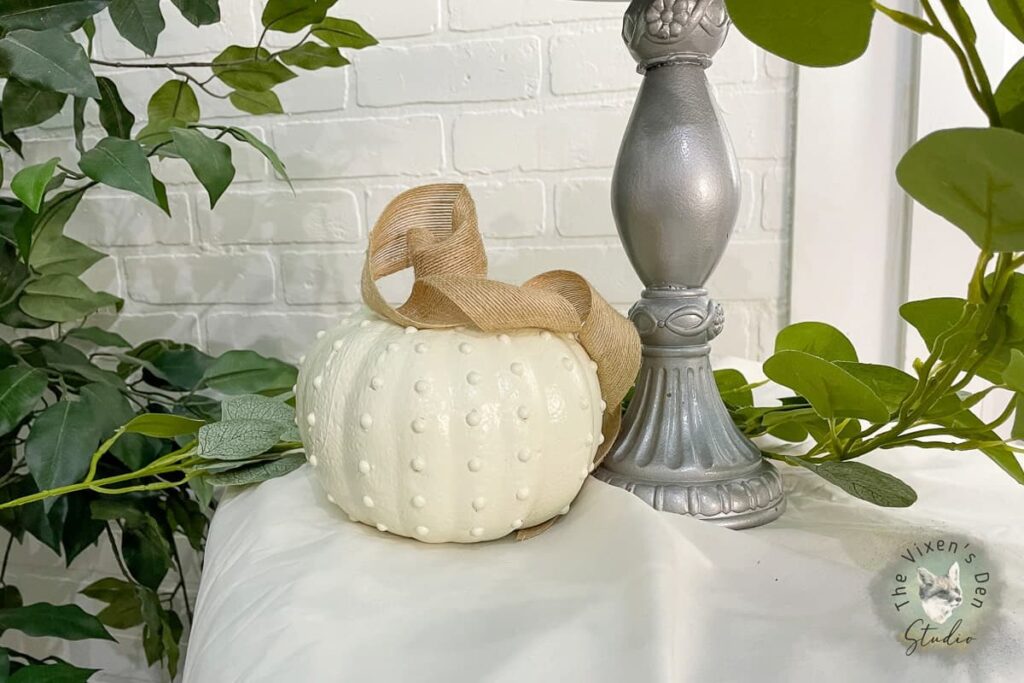 white pumpkin with hobnail bumps and burlap ribbon stem