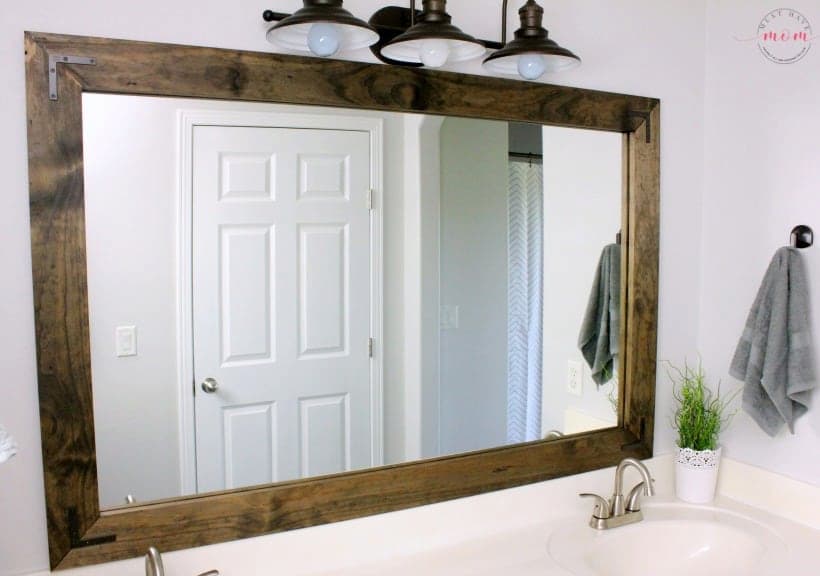Bathroom mirror trimmed in dark wood