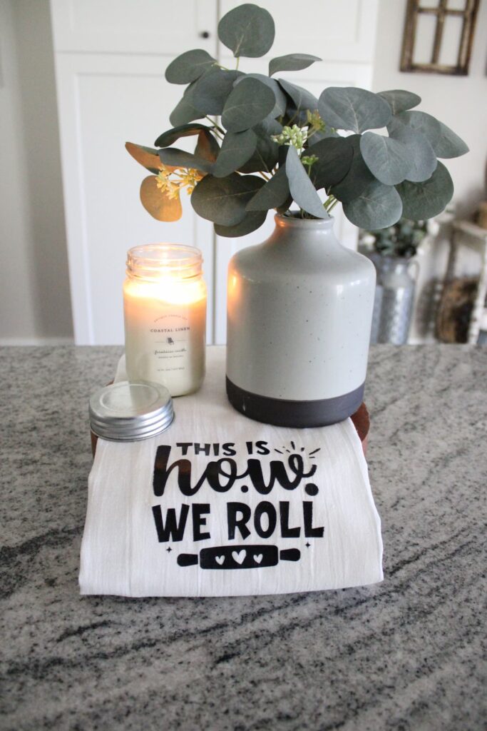 white tea towel with candle and plant