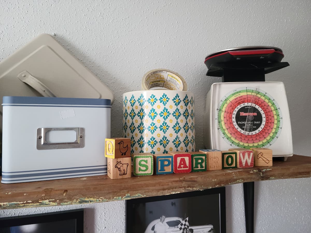 Shelving with metal recipe tin, blocks and scale