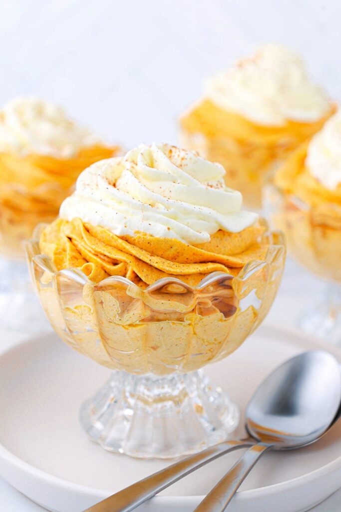 footed glass bowl with pumpkin mousse and whip cream