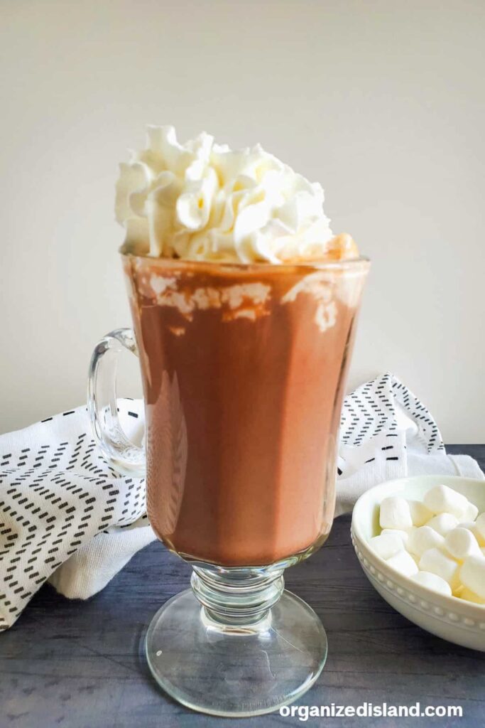 clear glass mug of hot cocoa with whipped cream