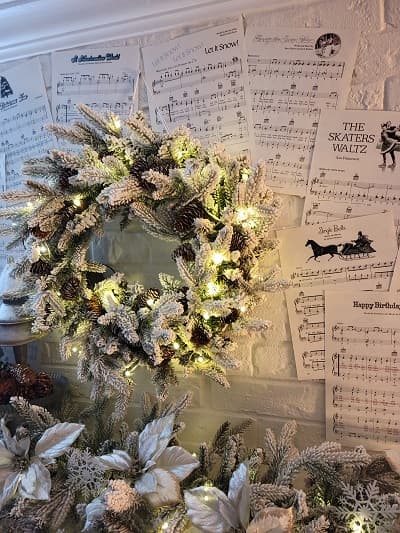 lightd king of christmas wreath on background of music sheets