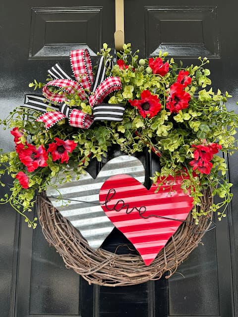 black door with grapevine wreath with flowers and hearts