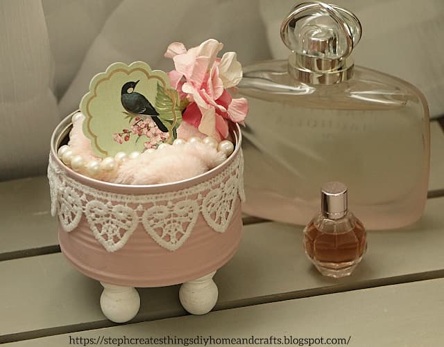 pink container on feet with bird and perfume