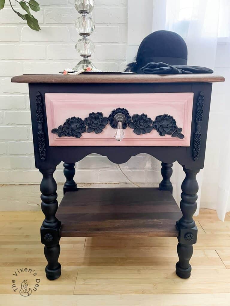 Black nightstand with pink drawer and black accents