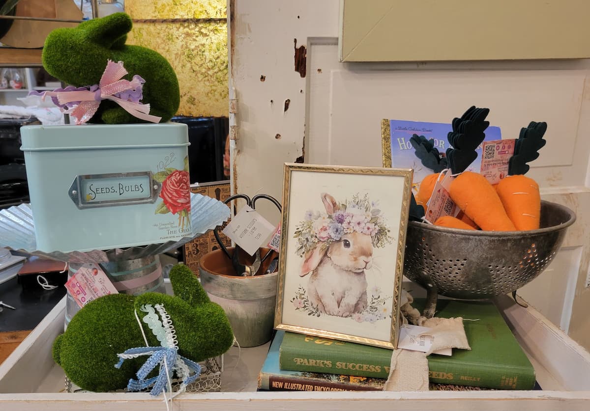 vignette with moss bunnies, felt carrots, colander and framed bunny print