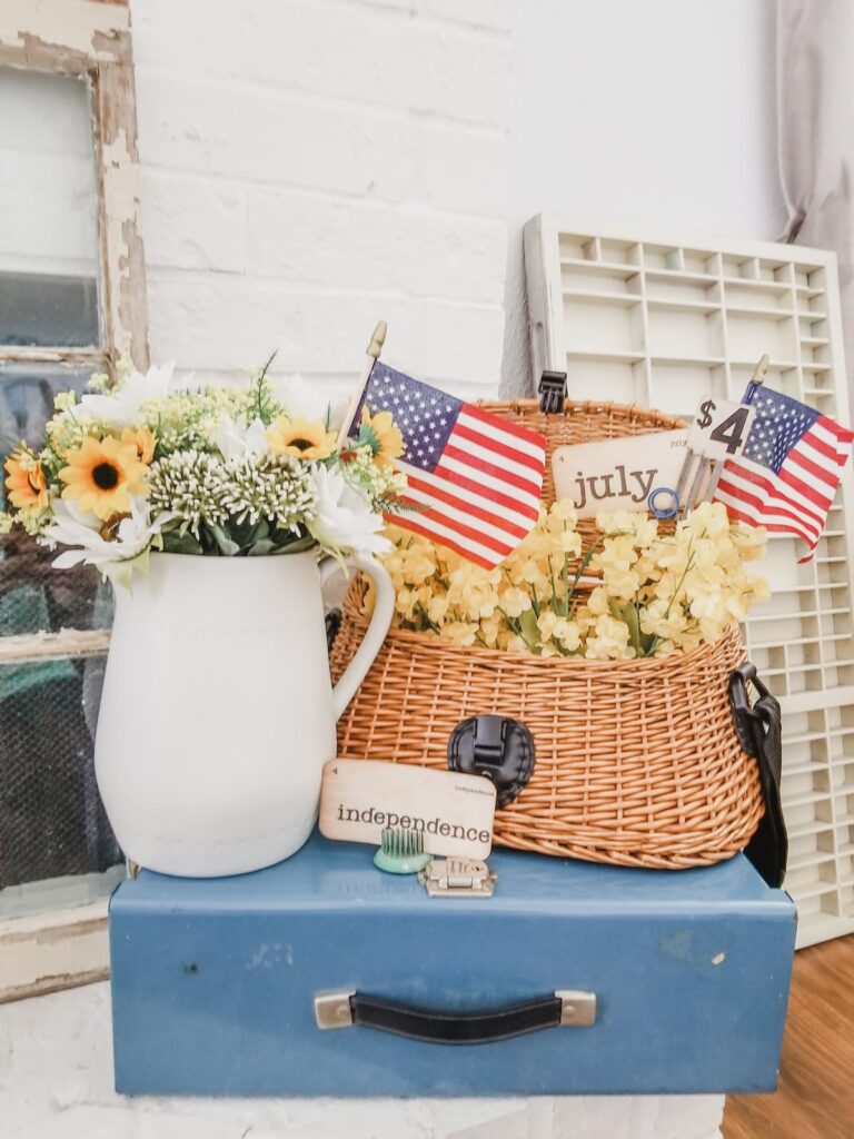 flowers in white pitcher, fishing creel with flowers and vintage flashcard on blue box