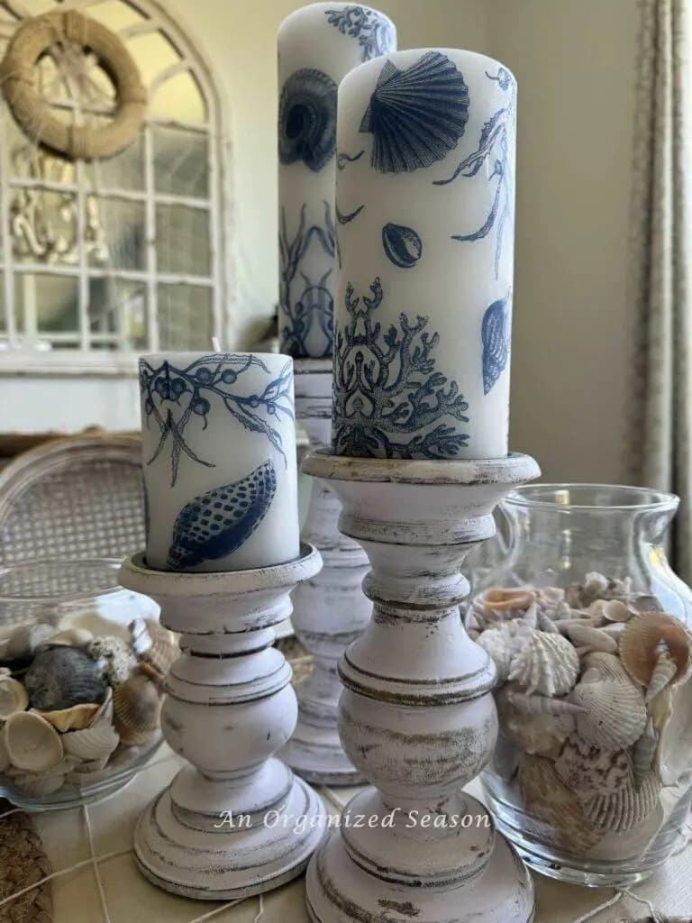 white candles with blue design on candle holders
