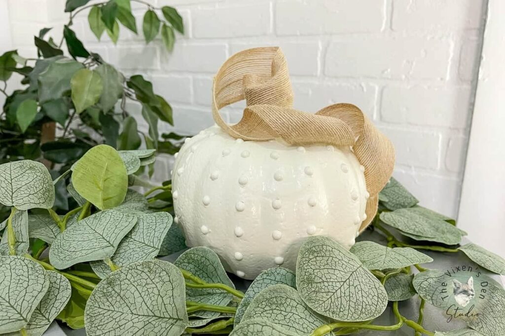 White hobnail pumpkin in greenery