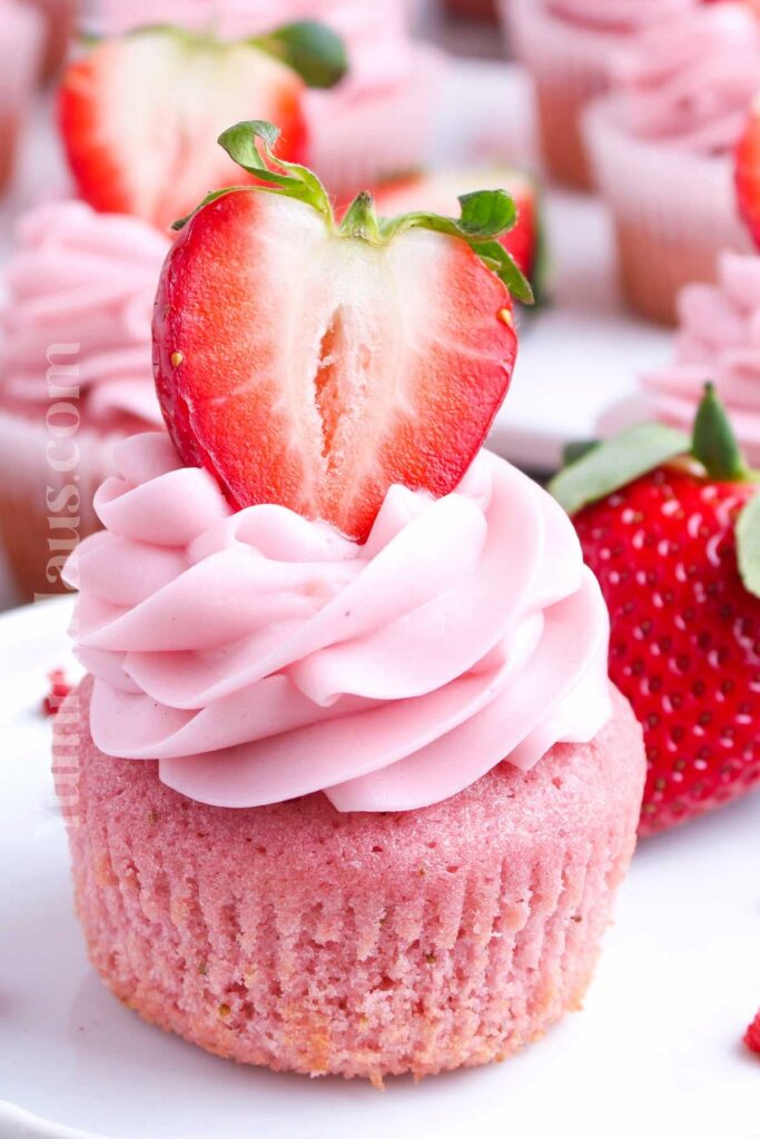 pink cupcake with icing and strawberry
