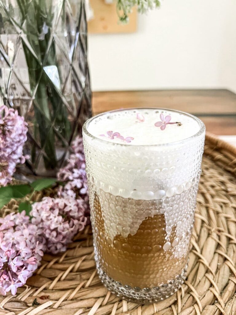 glass of coffee drink with lilacs
