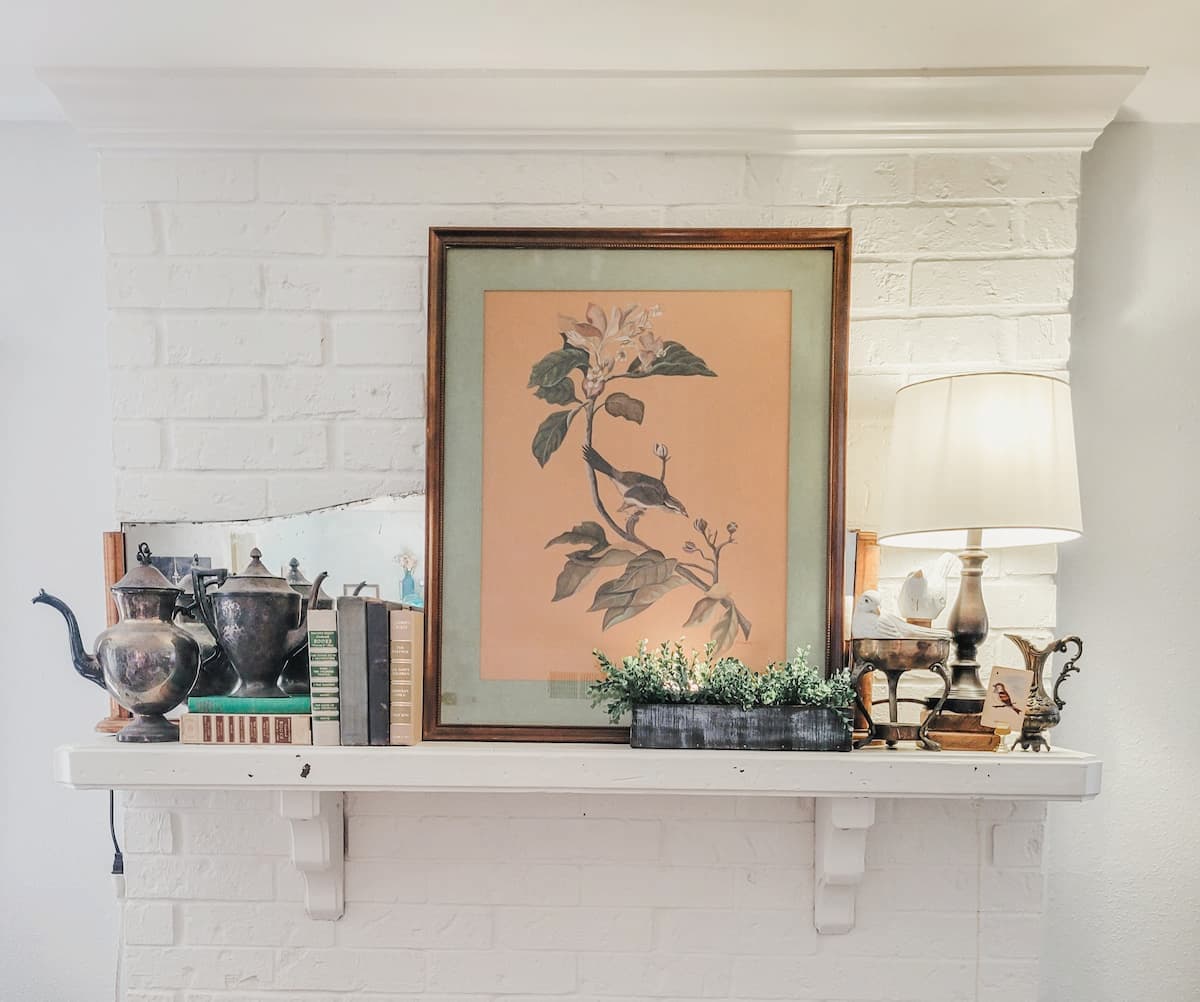 mantel with large print, lamp and books
