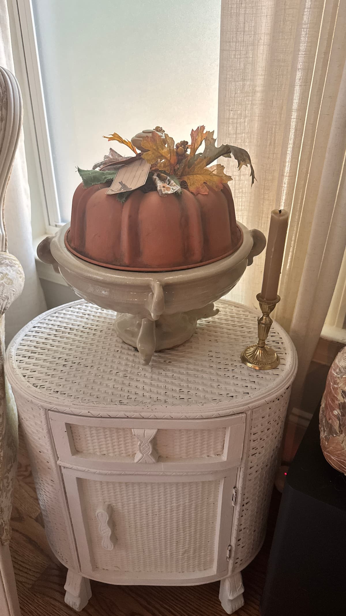 This is an easy pumpkin craft upcycled from a thrifted bundt pan. Paint, add a spindle and greenery to have an adorable pumpkin for fall decor.