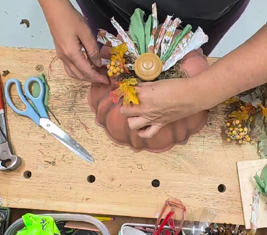 arranging floral on top of pumpkin